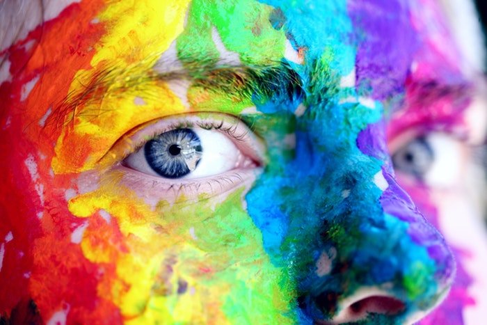Un primer plano de la cara de una persona cubierta de polvo Holi de color