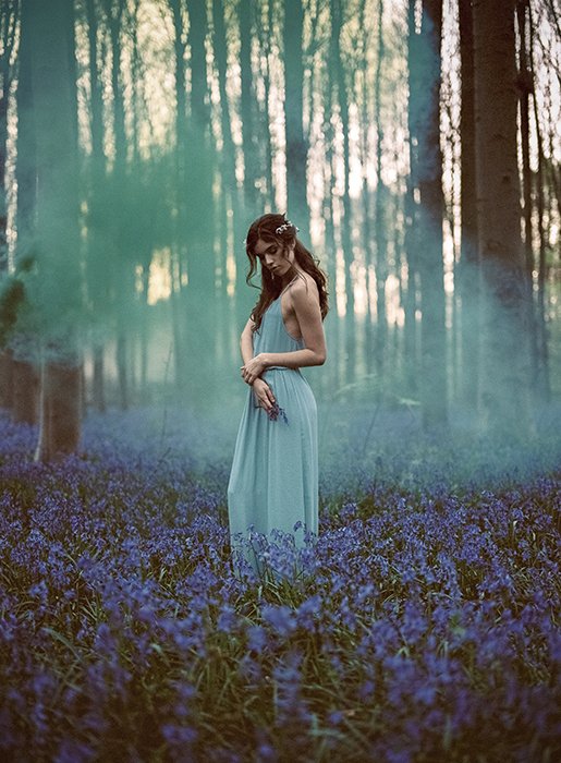 Un impresionante retrato estilo fotografía cinematográfica de una modelo femenina posando en un bosque de ensueño
