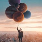 Fotografía artística de una niña sosteniendo planetas como globos