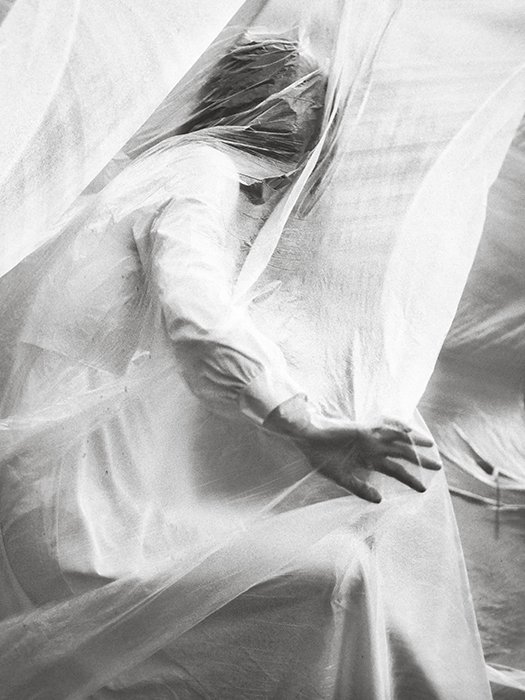 Retrato conceptual de bellas artes de una modelo femenina cubierta de material, rodada en blanco y negro