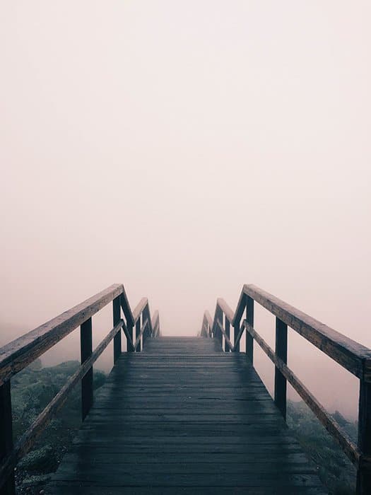 Retrato atmosférico de un puente de madera que desaparece en la niebla: errores de fotografía artística
