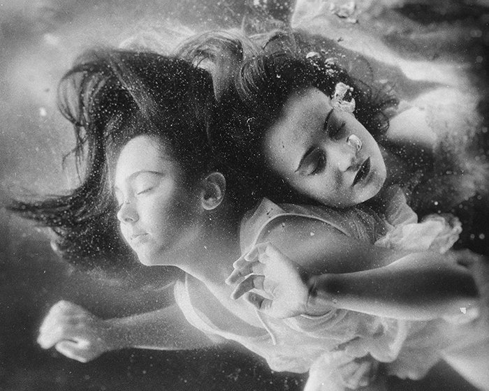 Retrato subacuático surrealista de dos modelos femeninos tomados en monótono: errores de fotografía de bellas artes