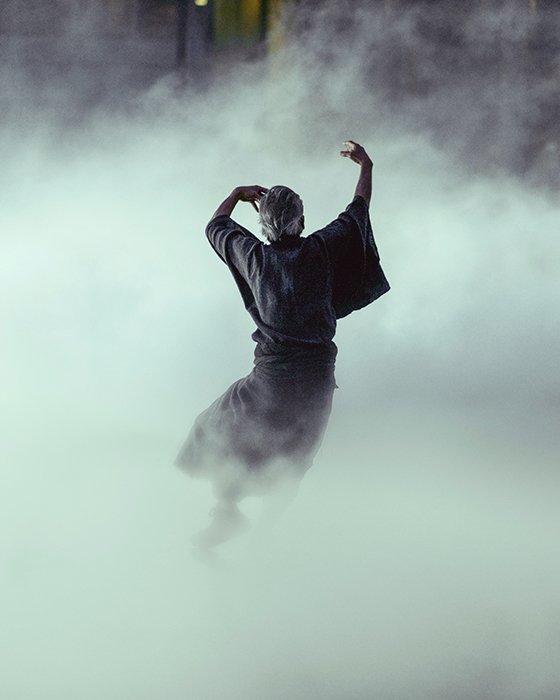 Fotografía de bellas artes atmosféricas retrato de una persona bailando en medio del humo o la niebla