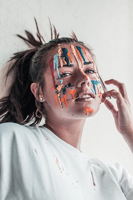 Retrato artístico de una mujer posando con pintura facial