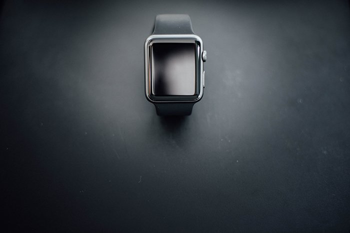 Fotografía de producto de arriba de un reloj negro sobre un fondo negro