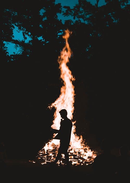 La silueta de una persona frente a una gran hoguera - fotografía de fuego