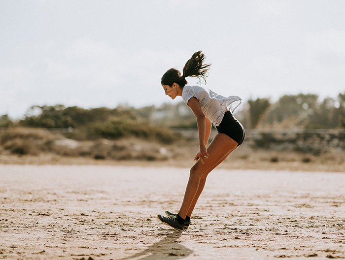 una mujer haciendo ejercicio en la playa