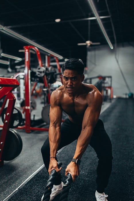 Un hombre levantando pesas en el gimnasio para una sesión de fotos de fitness