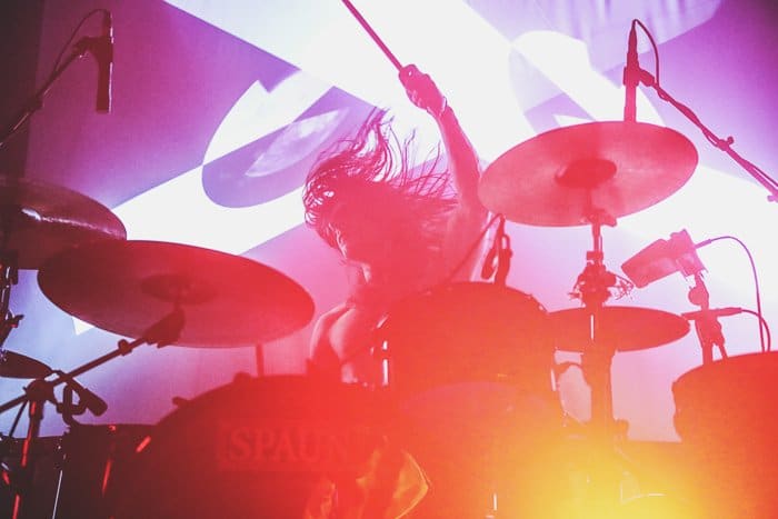 Una fotografía de concierto de un baterista con colores distorsionados 