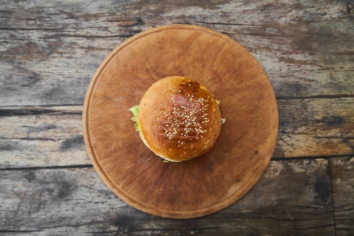 Foto de comida plana de una hamburguesa en un plato de madera