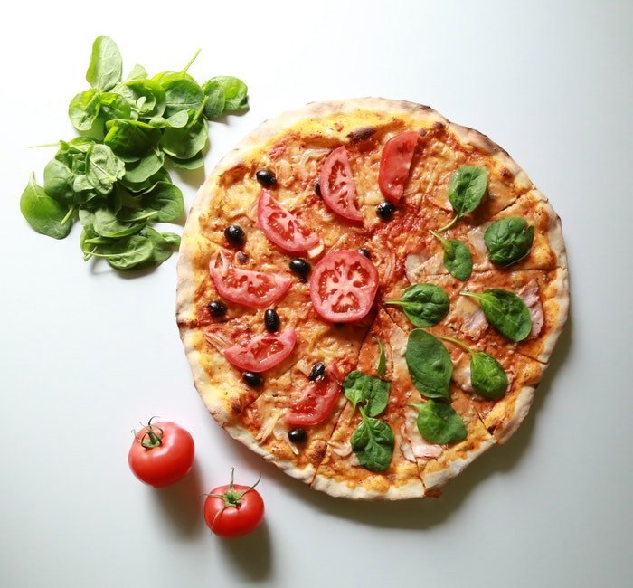 Foto de comida plana de una pizza más ingredientes adicionales