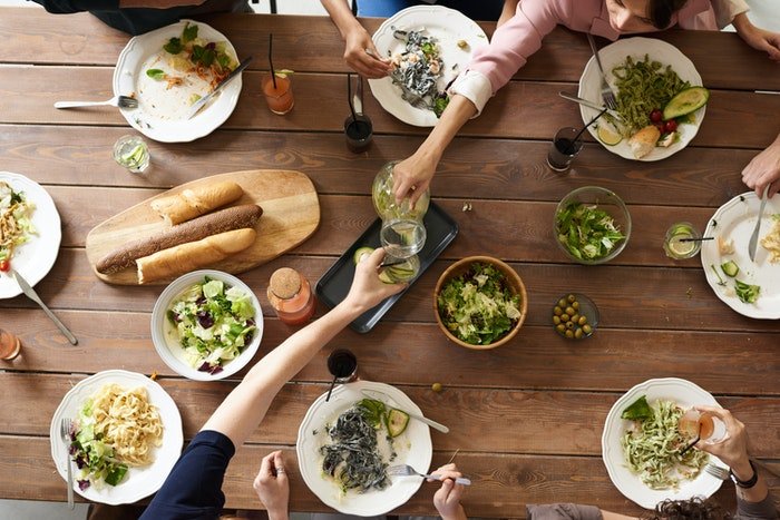 Foto plana de comida de personas compartiendo el almuerzo