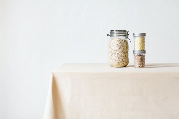 Alimentos secos en frascos de vidrio sobre un mantel de fotografía de alimentos sencillos