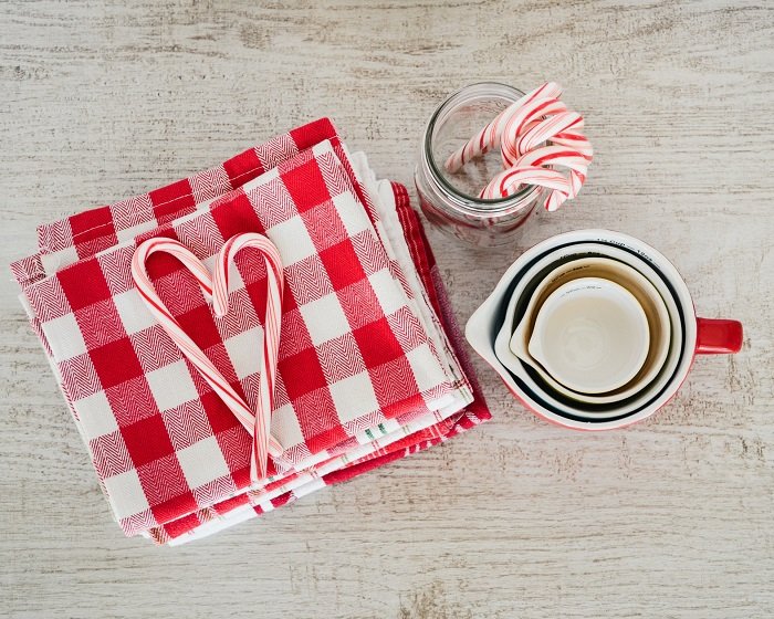 Bastones de caramelo en servilletas de tela a cuadros usadas como accesorios de fotografía de alimentos