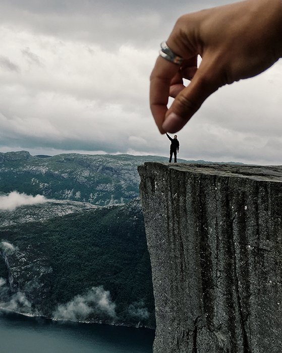 Ilusión de una enorme mano amiga estrechando la mano de un pequeño escalador.