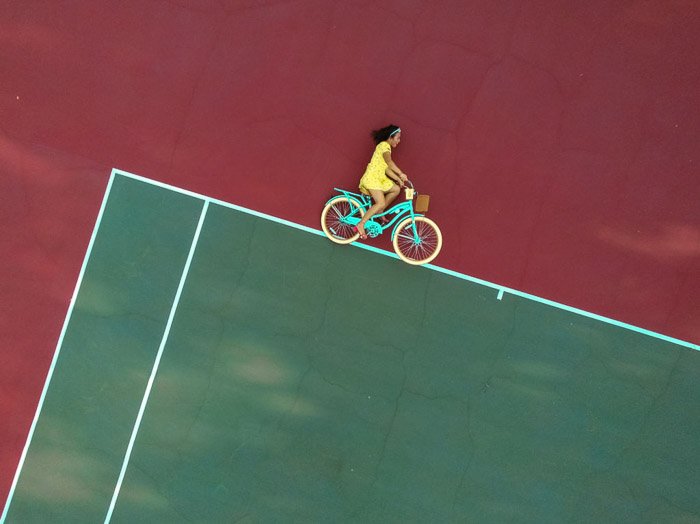 Foto de ilusión óptica de una chica en una bicicleta que parece que está montando en bicicleta en líneas abstractas