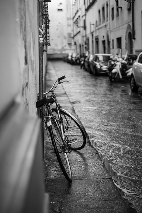 Una foto de la calle de una bicicleta apoyada contra una pared.