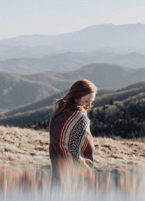 Retrato artístico de una modelo femenina posando en un paisaje montañoso tomado con filtros fractales