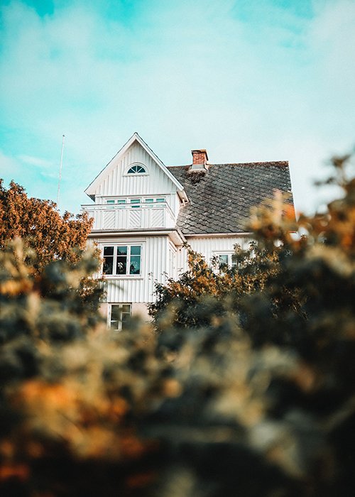 Foto de una casa con arbustos en primer plano.