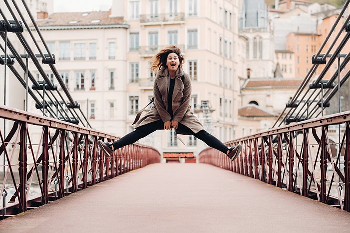 Chica salta sobre un puente simétrico.
