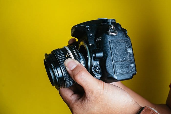 Una lente Nikon DSLR sobre fondo amarillo