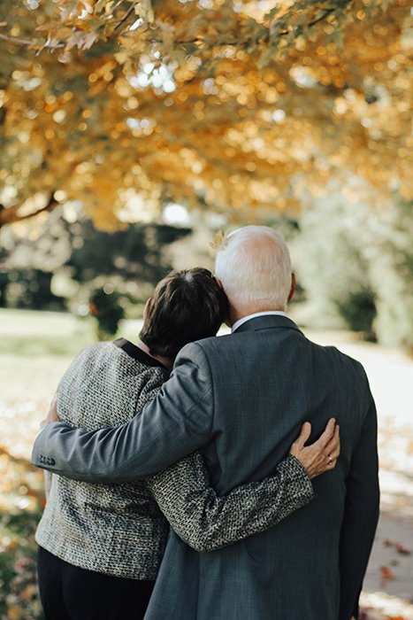 la espalda de una pareja de ancianos en un funeral