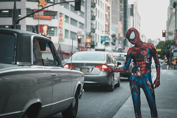 Un divertido retrato fotográfico de Spiderman llamando a un taxi