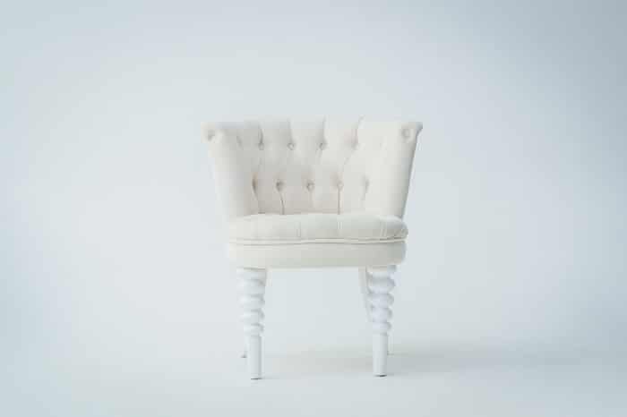 Elegante silla blanca sobre fondo blanco.