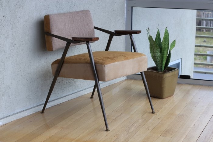 Foto de muebles de una silla marrón junto a una pared gris.