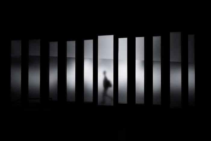 foto atmosférica de la silueta de una persona caminando a través de líneas que demuestran fotografía geométrica