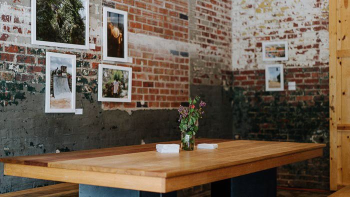 Una mesa de madera en una habitación de diseño rústico con una fotografía enmarcada en la pared