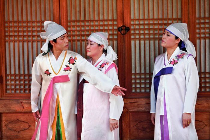 Tres personas vestidas con ropa tradicional.