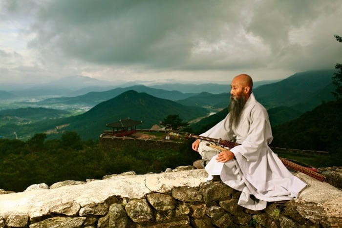 una imagen de un monje con colinas al fondo - fotografía de viaje
