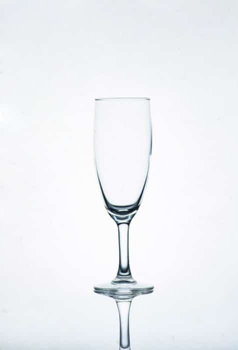 Una foto de una copa de champán sobre fondo blanco - consejos de fotografía de vidrio