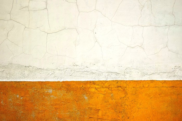 Un ejemplo simple y efectivo de fotografía abstracta de una pared blanca y amarilla agrietada