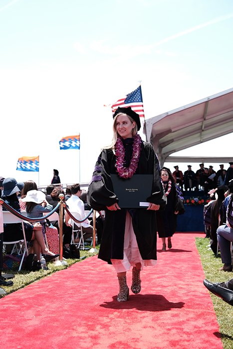 Hermoso retrato sincero de graduación de una estudiante caminando al aire libre