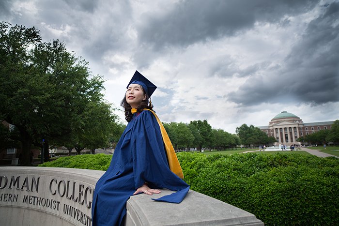 Hermoso retrato de graduación de una estudiante posando al aire libre