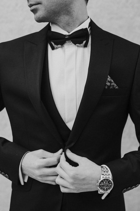 Fotografía en blanco y negro de un hombre con traje negro y corbatín