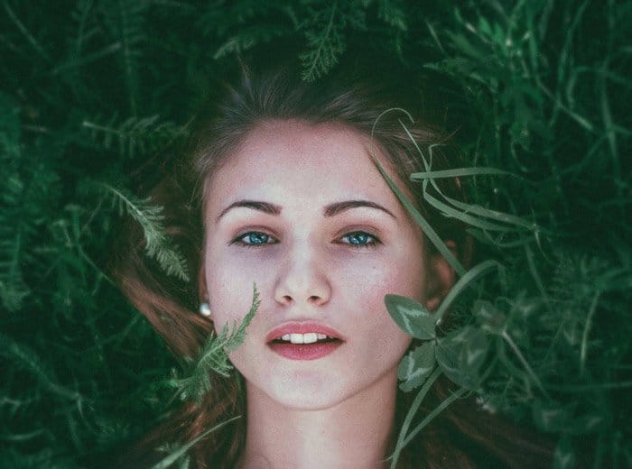 Foto de retrato de una mujer pelirroja tirada en la hierba