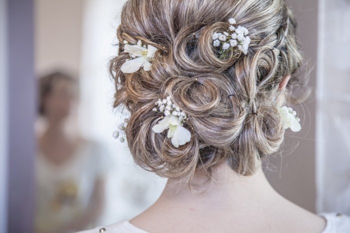 Un primer plano de un peinado de boda con flores pequeñas