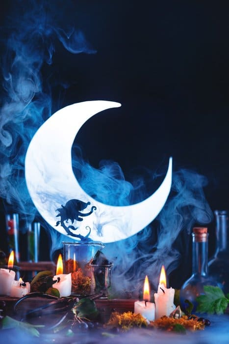 Bodegón atmosférico de Halloween con las siluetas, una luna creciente y otros accesorios espeluznantes