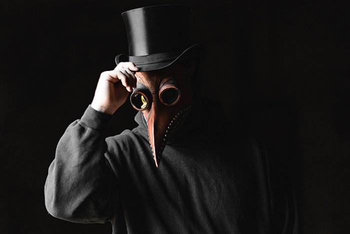 Una persona con una máscara aterradora frente a un fondo negro