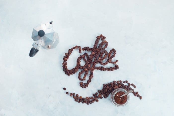 Una creativa disposición plana de tipografía de alimentos y granos de café.