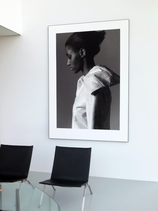 Una foto ampliada en blanco y negro de una mujer enmarcada y colgada en la pared de una sala de estar