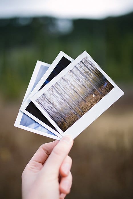 Una persona con tres fotos polaroid - look de fotografía cinematográfica