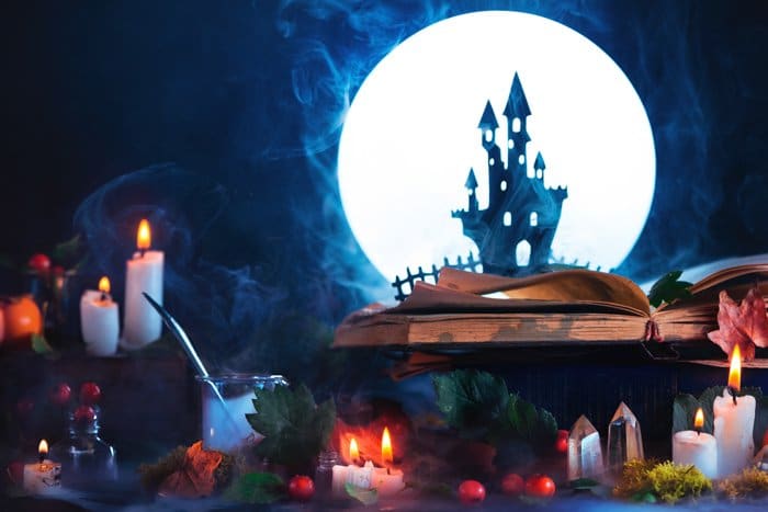 Una naturaleza muerta con la silueta de un castillo espeluznante, una luna llena, velas y otros accesorios espeluznantes: imágenes geniales de Halloween