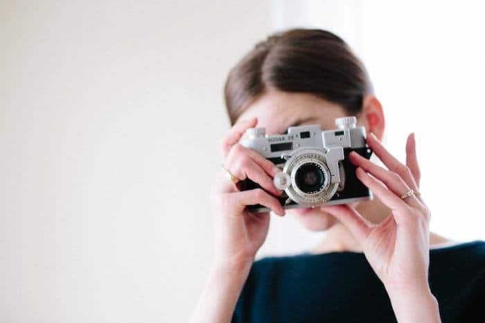 Mujer tomando una fotografía con una cámara digital Kodak