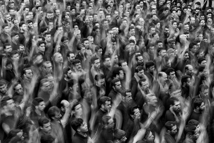 Una fotografía aérea en blanco y negro de una multitud de personas con las manos levantadas en el aire