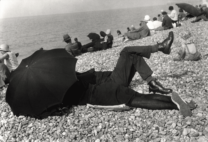 Imagen de Henri Cartier-Bresson de un hombre y una mujer bajo una sombrilla en la playa