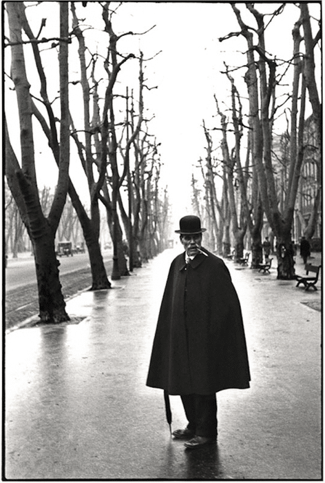 una imagen en blanco y negro de henri cartier-bresson de un hombre dentro de dos hileras de árboles
